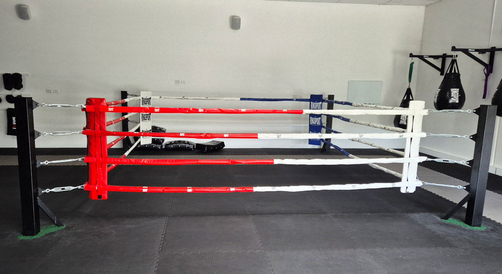Boxing floor ring with red and white ropes in a boxing gym
